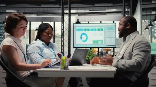 Office Colleagues Meeting at Table with Laptop