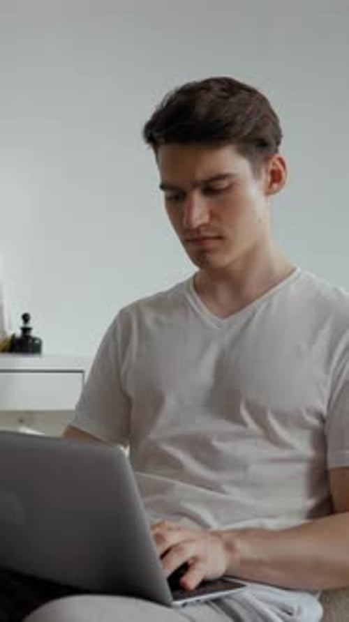 Man Works on Laptop Computer in Home Interior