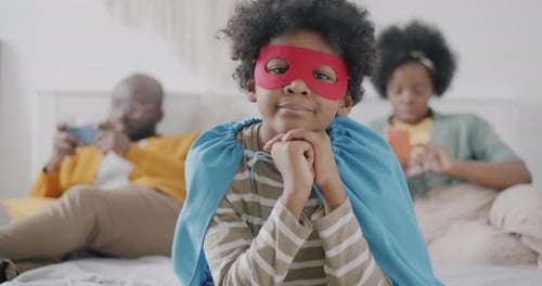 Young Boy in Superhero Costume with Family at Home