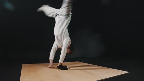 Young Athletic Man Dancer Showing a Breakdance Trick on His