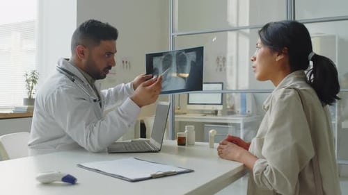 Doctor Explaining X-Ray to Patient in Office