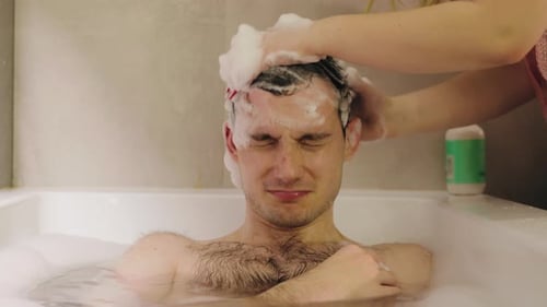 Man Relaxing in Bubble Bath Getting Hair Washed