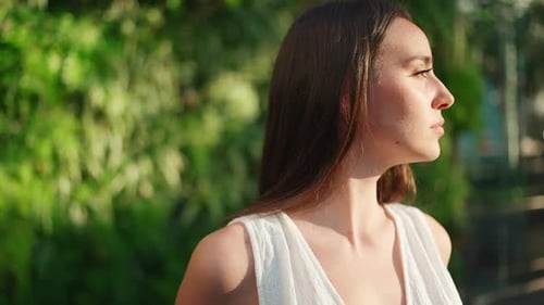 Young Woman Posing in Front of Green Foliage