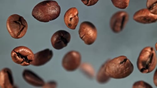 Superzeitlupen-Kaffeebohnen mit Rauch, gefilmt auf einer Hochgeschwindigkeitskamera mit 1000 Bildern pro Sekunde