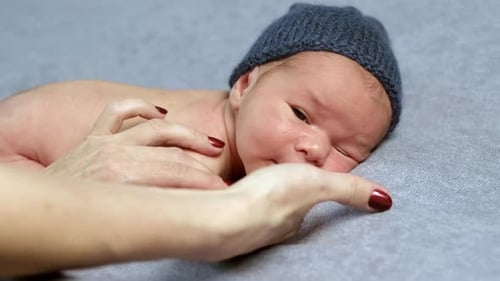 Parent Comforting Newborn Infant Lying on Tummy