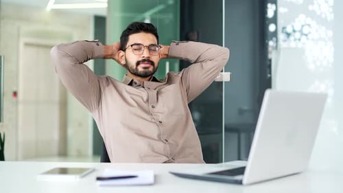 Young Adult Relaxing at Desk with Laptop