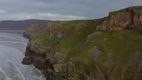 Sea waves breaking over rocks. Waters of the ocean, swirl around the rocky and scenic coastline.