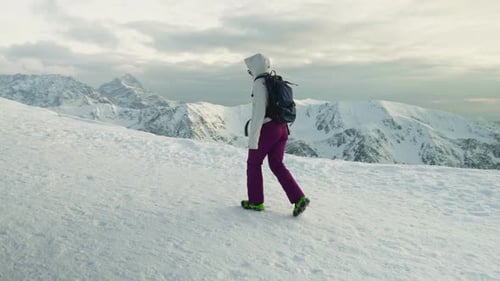Woman Hikes On The Snow-covered Mountain During Winter. - wide shot