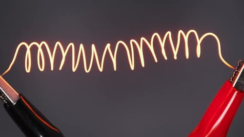 Nichrome Filament Connected to Power Wires is Heated to Red Under Large Current