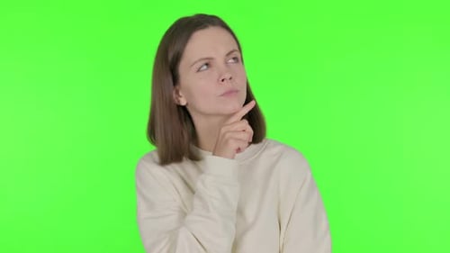 Pensive Young Woman Thinking New Idea on Green Background