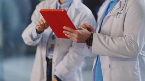 Medical Professionals Discussing Patient Data on a Tablet
