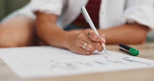 Woman Writes on Calendar at Desk Indoors