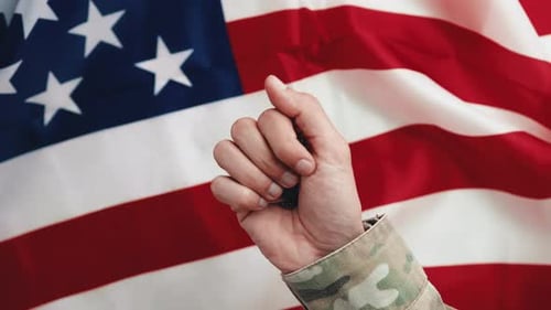 Hand Holding Military Dog Tags by American Flag