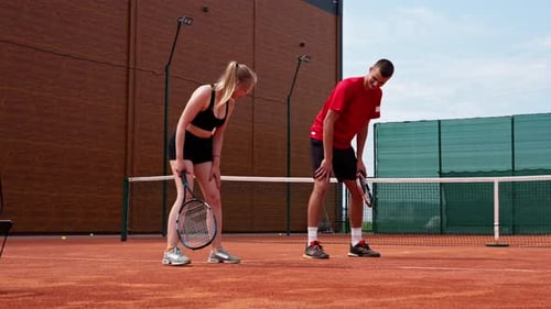 Tennis Players Resting on Outdoor Court in Daytime