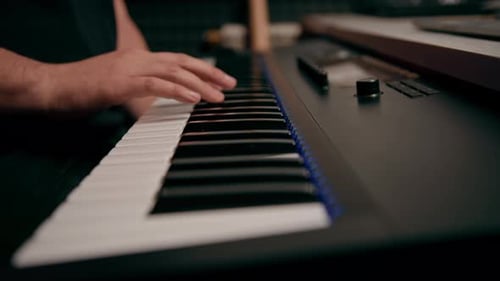 professional recording studio sound engineer or music producer musician pressing synthesizer keys