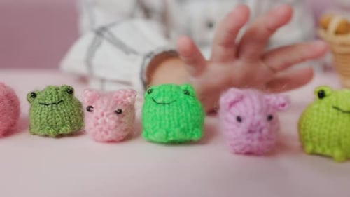 Mädchen spielt mit kleinen gestrickten Tierspielzeugen in einem Zimmer zu Hause