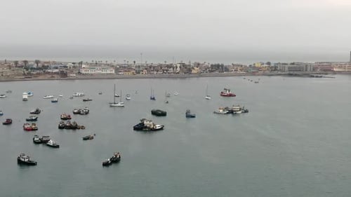 Ships anchored in Callao Harbor coastline in Lima Peru, pan shot of La Punta