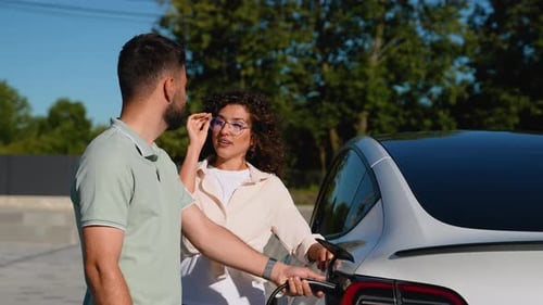 Happy Couple Charging Their Modern Electric Car