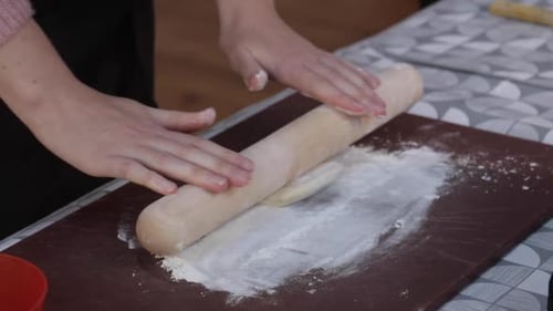 Woman Rolling Dough with a Wooden Rolling Pin