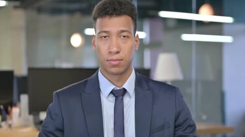 Confident Young Adult in Suit Looking at Camera