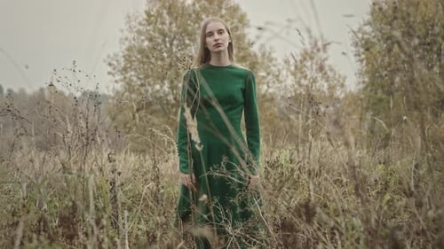 Model posing wearing green dress in a field