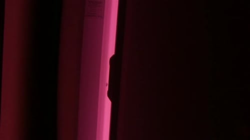 Illuminated Tanning Bed Glowing in Dark Room