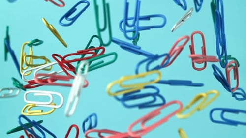 Colorful Paperclips Floating on Light Blue Background