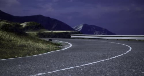 Curving Road Under the Night Sky Near Mountain Landscape
