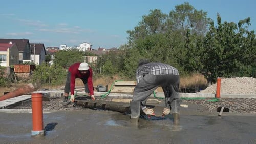 Bauarbeiter nivellieren Baustelle unter blauem Himmel