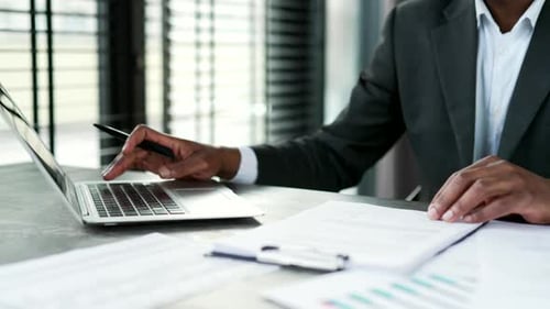 Close up of male hands typing on laptop keyboard in modern office. African american businessman work
