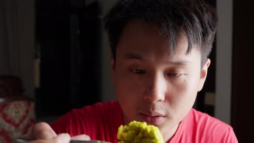 Young Adult Eating Green Food with Spoon