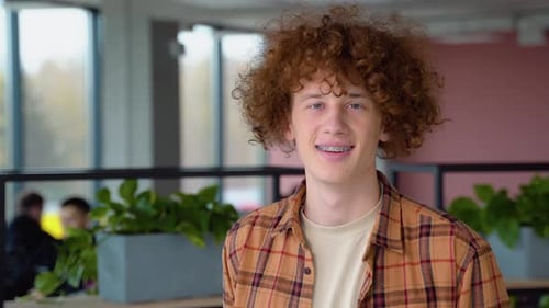 Young Man Smiling Indoors in Office Environment