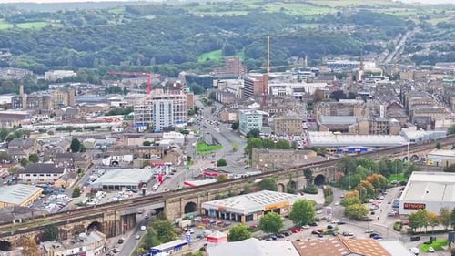 Train tracks, town centre and and forest in Huddersfield, UK, aerial