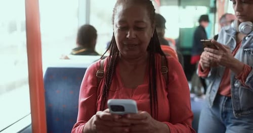 People riding public transport looking at their phones