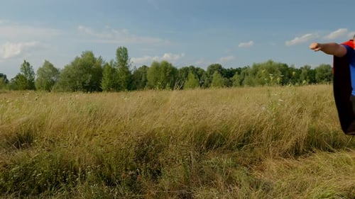 Carefree Father and Little Girl Running in Superhero Flying Pose on Field