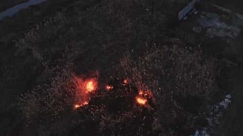 Abendbrand auf einem Feld in der Nähe der Stadt Brennendes Schilf in der Nähe von Häusern Saisonale Brände in der Steppe