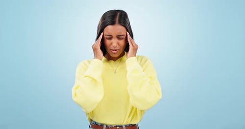 Stress, anxiety and woman with headache in studio worry, fear or burnout on blue background