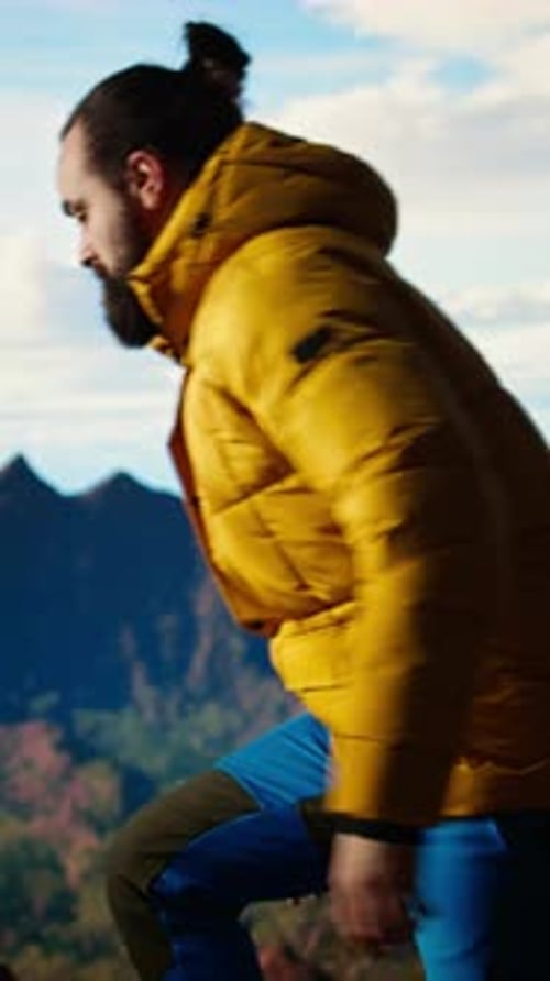 Vertical Video Determined Climber Pauses to Admire the Scenic View with Mountains and Vast Sky