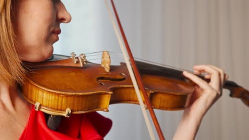 Woman plays the violin in simple setting