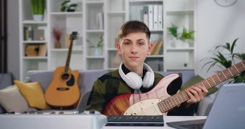 Portrait Smiling Boy Looking at Camera. European Male Learning an Electro Guitar in Home Studio