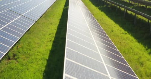 Aerial View of Solar Panels on Green Field