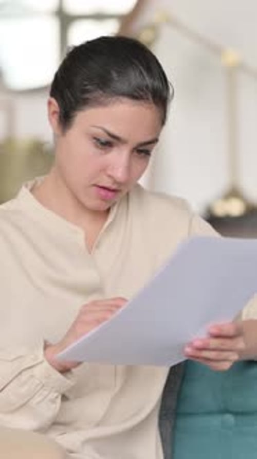 Concentrated Young Woman Reviewing Documents at Home