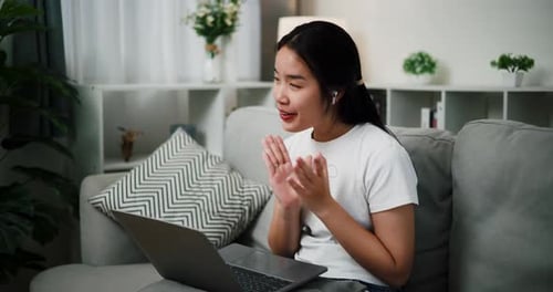 Young Woman Video Chatting on Laptop at Home