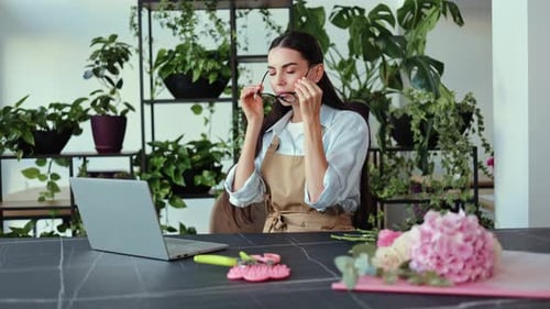 Woman with Glasses Working on Laptop with Flowers