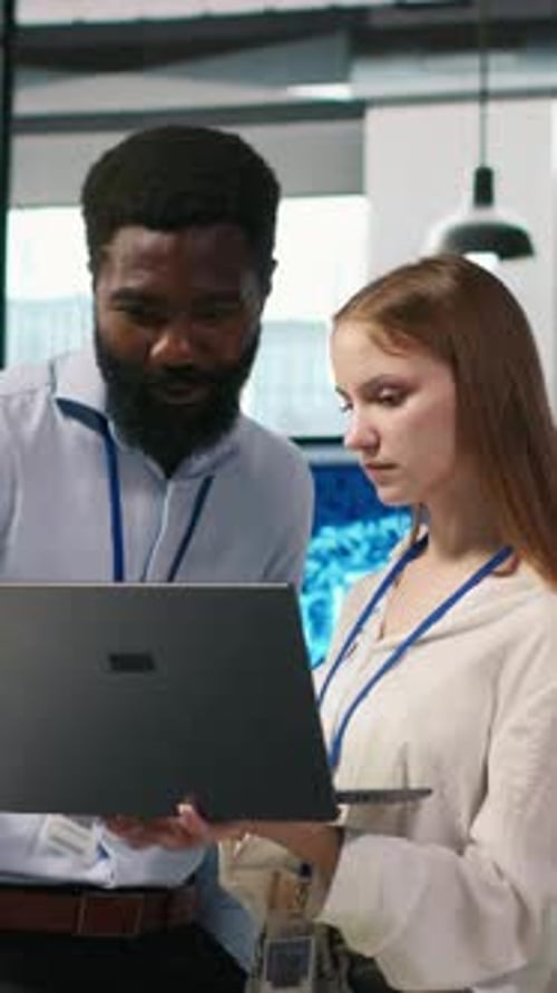 Vertical Video Junior Dev and Colleague in Office Reviewing AI System Metrics