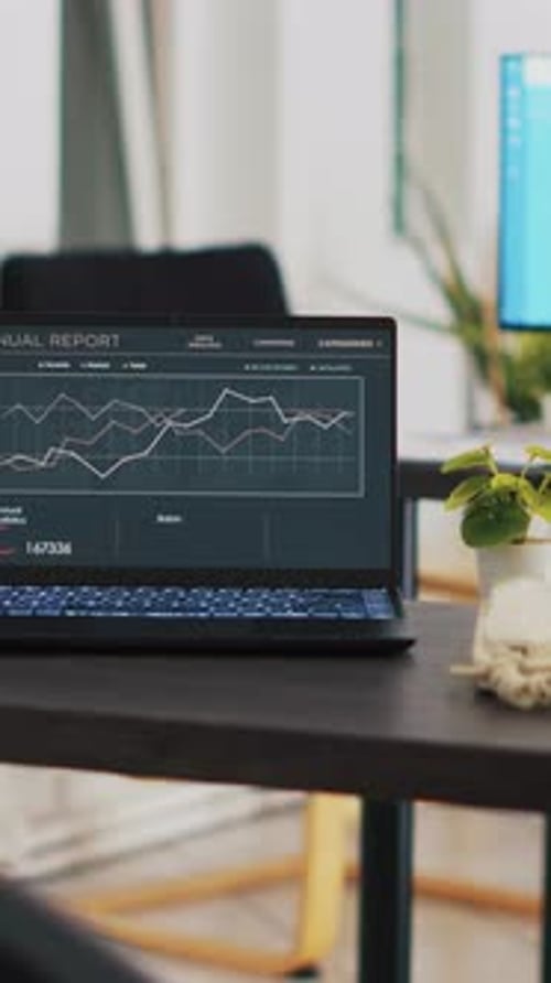 Vertical Video Business Forecasting Graphs on Laptop Sitting on Workspace Desk