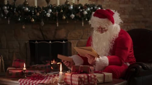 Santa Reading Letters by Fireplace at Christmas