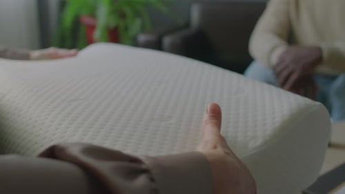 Woman Compresses New White Pillow in Home