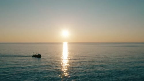 Industrial Fishing Boat Navigating In Tranquil Ocean During Sunset. Aerial Wide Shot