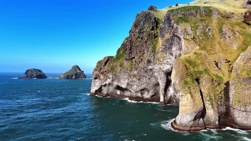 Beautiful cliffs covered with moss towering above the waterscape of the Atlantic Ocean.